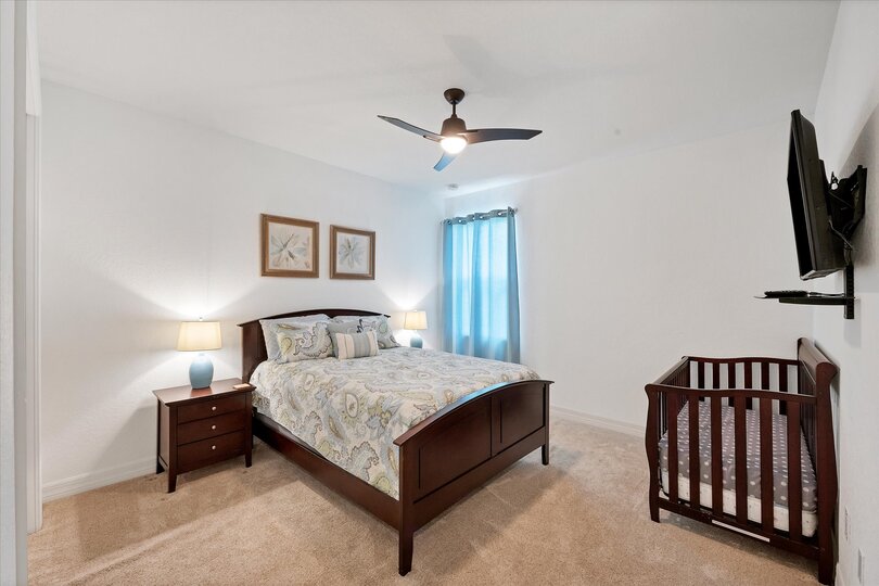 Guest bedroom with queen bed, full-size crib and 43-inch Smart TV