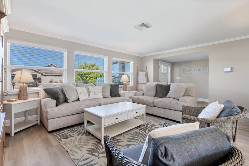 Bright, open living room with lots of comfy seating and 65-inch Smart TV