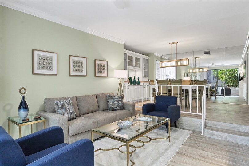 Living room with 55-inch TV, balcony access, and queen sofa bed