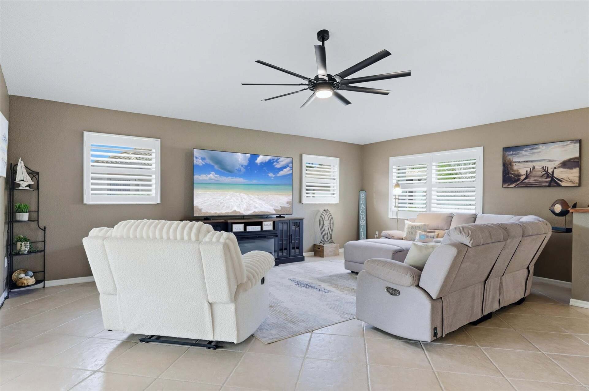 Living room features lots of comfy seating, patio access, and 85-inch Smart TV