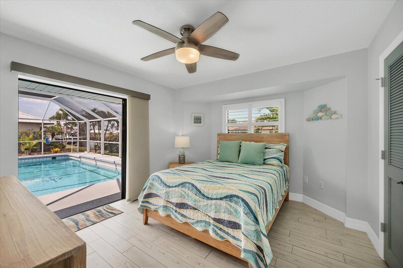Guest bedroom with Queen bed, lanai Access, and 32" Smart TV