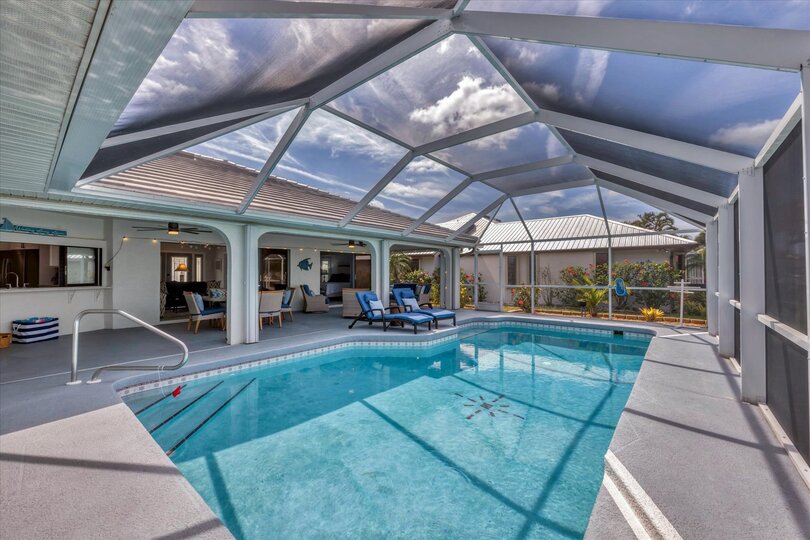 The Best of Florida Outdoor Living. Screened In Lanai overlooking the sparkling private pool and canal with 32" TV