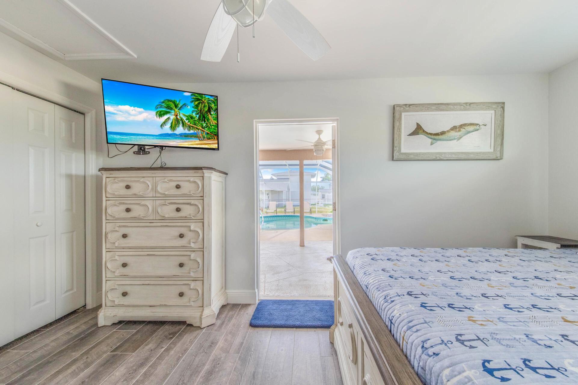 Guest bedroom 3 (off of garage) with full-size bed, attached bathroom, lanai access, 43-inch Smart TV, and private entry
