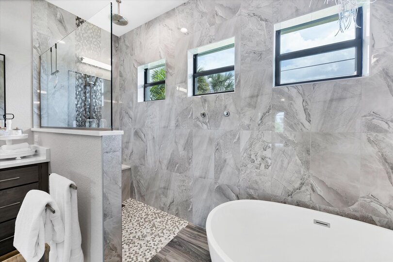 Primary bedroom's attached bathroom with large walk-in shower, double vanities and a relaxing soaking tub