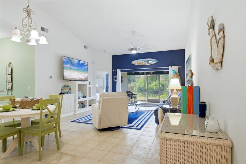Large living space includes patio access overlooking the pond, and 75-inch Smart TV