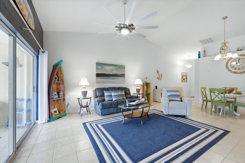 Large living space includes patio access overlooking the pond, and 75-inch Smart TV