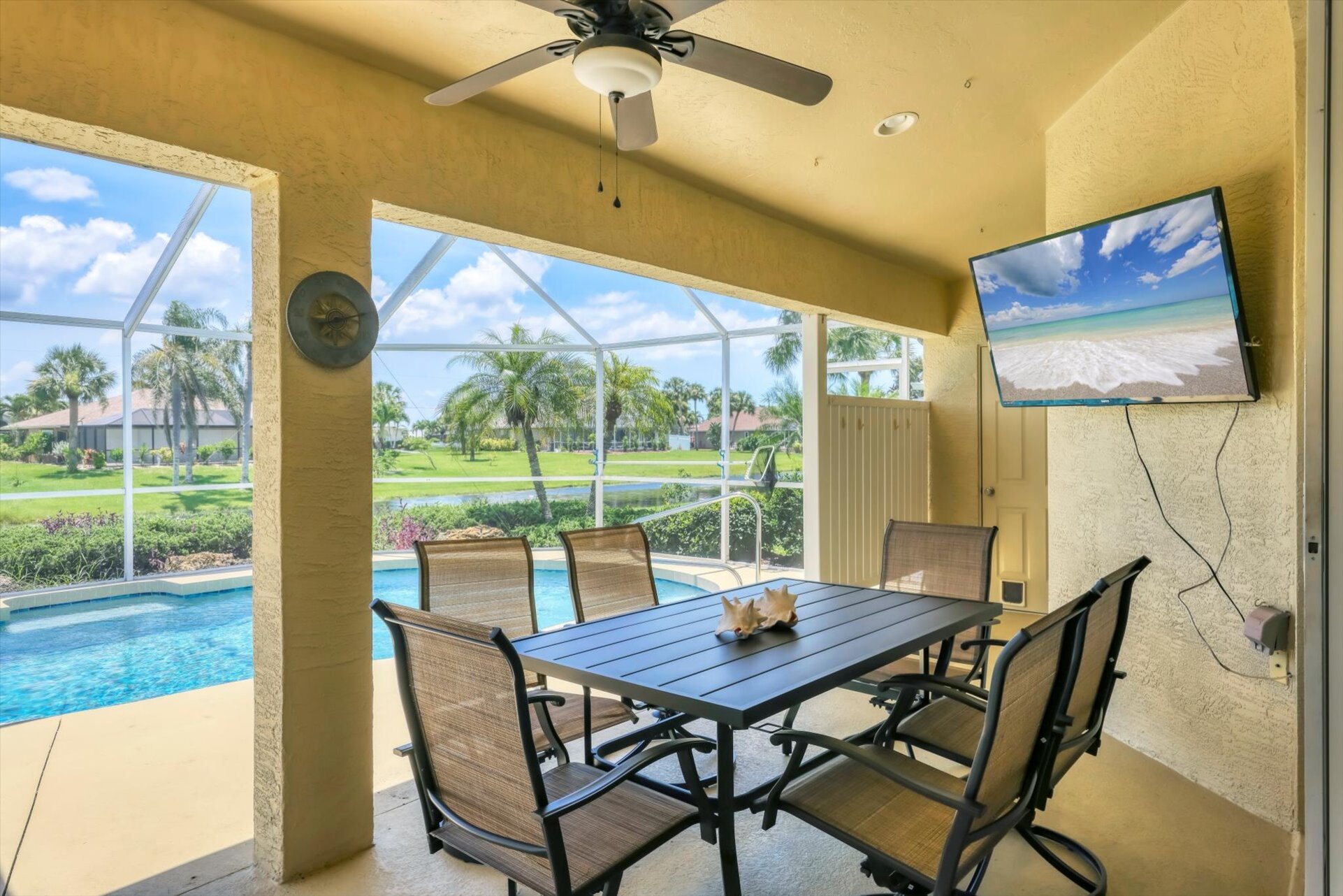 Large outoor living area overlooking the sparkling pool and canal