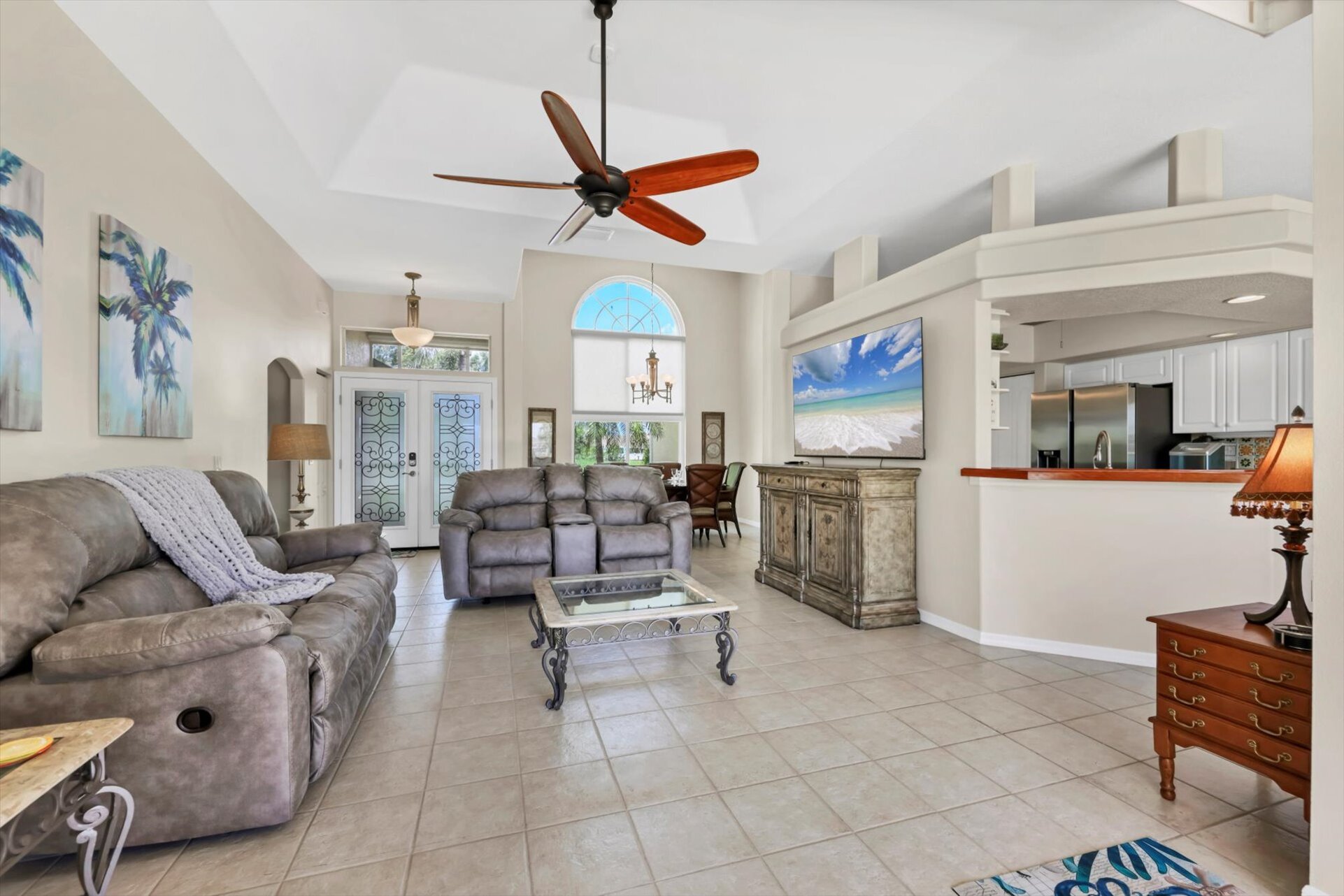 Living room overlooking pool. Living room features plenty of comfy seating and 75-inch Smart TV