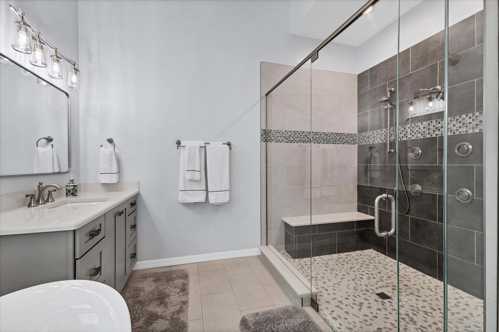 Primary en suite with large walk-in shower, soaking tub, and double vanities