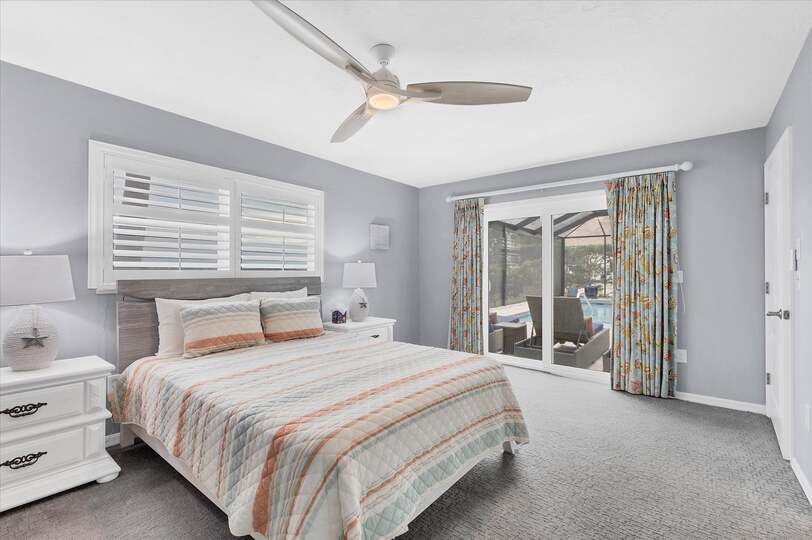 Guest bedroom with queen bed, attached bathroom, lanai access, and 50-inch Smart TV