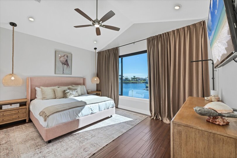 Guest bedroom 1 with king bed 65-inch Smart TV, and fabulous water view