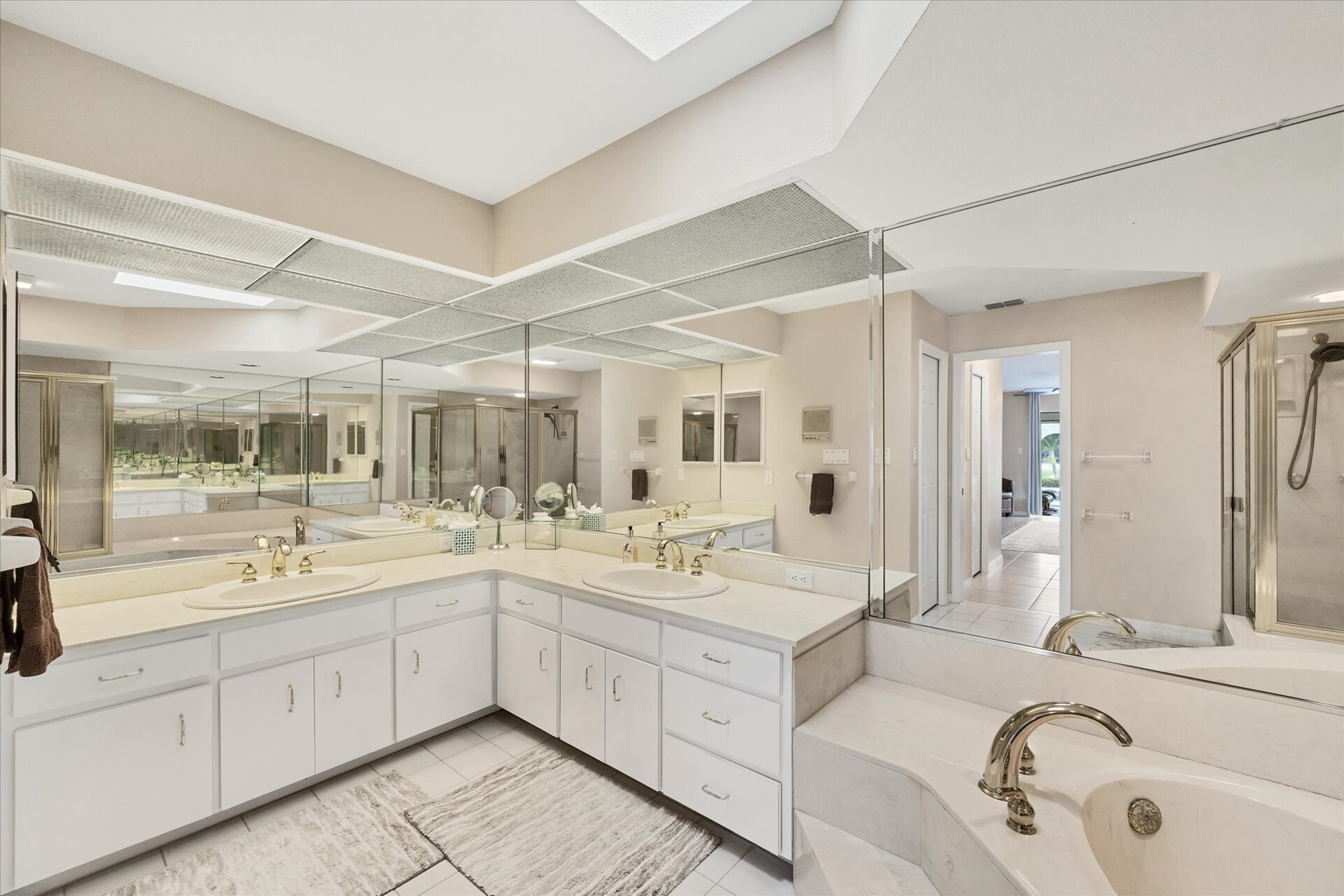 Primary Bathroom with large walk-in shower, double vanities, and bath tub